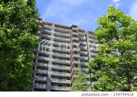A distant view of the exterior of the "Gardenaville Ichikawa Myoden" condominium, surrounded by blue skies and lush green trees. A distant view of the exterior of the "Gardenaville Ichikawa Myoden" condominium, surrounded by blue skies and lush green trees. 139749426