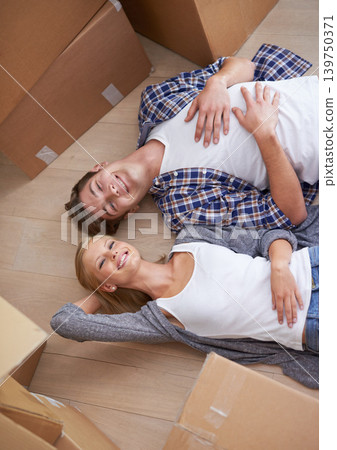 Couple, floor and moving or boxes for relax from packing or real estate property or bonding, marriage or apartment. Man, woman and rest for investment loan or mortgage for relocation, rent or buy 139750371