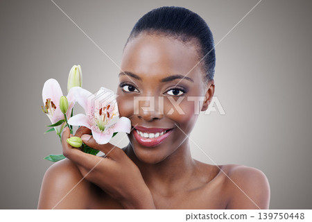 Portrait, smile for beauty and black woman with flowers in studio on gray background for natural skincare. Face, happy and confident young model with orchid for aesthetic wellness or cosmetics Portrait, smile for beauty and black woman with flowers in studio on gray background for natural skincare. Face, happy and confident young model with orchid for aesthetic wellness or cosmetics 139750448