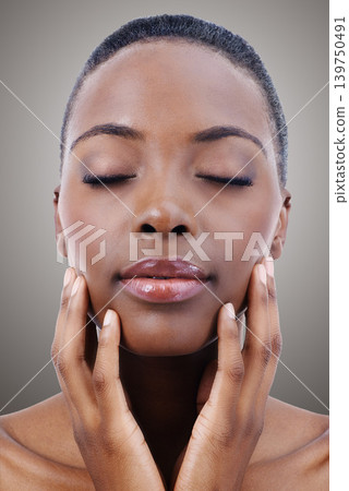 Face, beauty and relax with natural black woman in studio on gray background or wellness aesthetic. Skincare, makeup and cosmetics with young person at spa for facial treatment or dermatology Face, beauty and relax with natural black woman in studio on gray background or wellness aesthetic. Skincare, makeup and cosmetics with young person at spa for facial treatment or dermatology 139750491