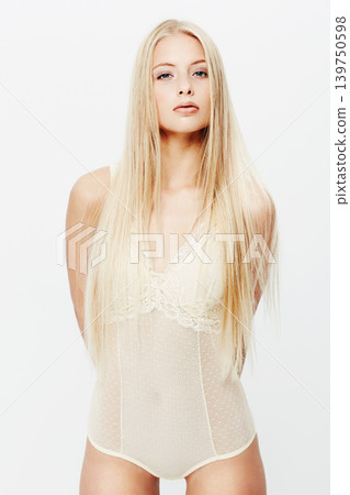 Portrait, model or beauty in lingerie in studio, confident or underwear for glow of body care. Young woman, face and cosmetics in trendy clothes with pride, blonde hair and makeup by white background 139750598