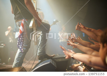 Rock concert, crowd and guitarist on a stage, fans and performance with music festival or audience. Event, people or artist with a band or group reaching for famous person or sound with live musician Rock concert, crowd and guitarist on a stage, fans and performance with music festival or audience. Event, people or artist with a band or group reaching for famous person or sound with live musician 139751153