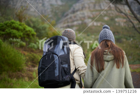 Outdoor, hiking and couple in mountain, holding hands and walking with backpack, nature and bonding together. Forest, adventure and trekking in path, field and exercise for fitness and travel Outdoor, hiking and couple in mountain, holding hands and walking with backpack, nature and bonding together. Forest, adventure and trekking in path, field and exercise for fitness and travel 139751216