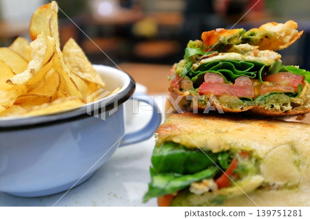 A hearty sandwich and potato chips – a classic cafe lunch set. A hearty sandwich and potato chips – a classic cafe lunch set. 139751281
