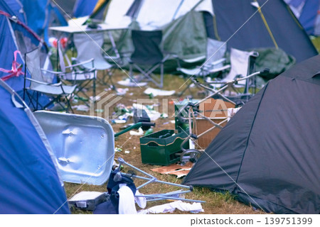 Tents, trash and mess at an outdoor music festival or event for a celebration party or social gathering. Summer, campsite and dirty with untidy camping gear, chairs or cooler boxes on the ground Tents, trash and mess at an outdoor music festival or event for a celebration party or social gathering. Summer, campsite and dirty with untidy camping gear, chairs or cooler boxes on the ground 139751399