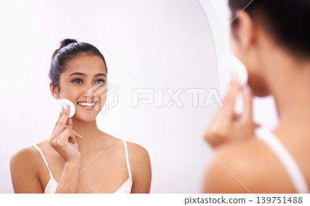 Happy woman, cotton pad and face in mirror for makeup, skincare or cosmetics in bathroom at home. Attractive female person or model smile for grooming, facial treatment or removal in reflection Happy woman, cotton pad and face in mirror for makeup, skincare or cosmetics in bathroom at home. Attractive female person or model smile for grooming, facial treatment or removal in reflection 139751488