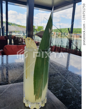 Refreshing Tropical Pineapple Cocktail in Tall Glass at Waterfront Restaurant Refreshing Tropical Pineapple Cocktail in Tall Glass at Waterfront Restaurant 139751750