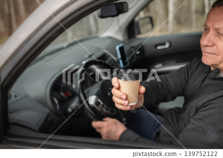 Close Up Takeaway Coffee In Hand Inside Car Interior Close Up Takeaway Coffee In Hand Inside Car Interior 139752122