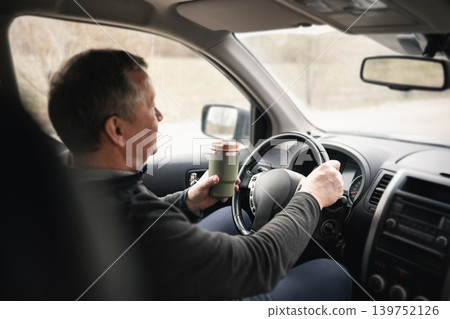 Driver Using Smartphone And Holding Coffee While Driving Car Driver Using Smartphone And Holding Coffee While Driving Car 139752126