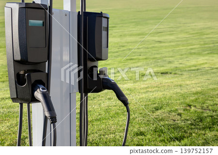 Electric vehicle charging station with two chargers in green field Electric vehicle charging station with two chargers in green field 139752157