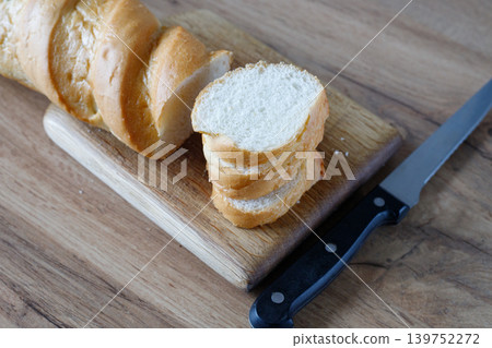 Fresh baguette sliced with a knife. Rustic, handmade rye bread with a golden crust and soft crumb is perfect for cooking, baking Fresh baguette sliced with a knife. Rustic, handmade rye bread with a golden crust and soft crumb is perfect for cooking, baking 139752272