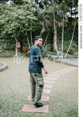 Southeast Asian Man Standing Outdoors Looking Back at Camera Southeast Asian Man Standing Outdoors Looking Back at Camera 139752554