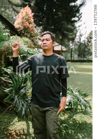 Asian Male Showing Idea Gesture While Pointing Up Outdoors Asian Male Showing Idea Gesture While Pointing Up Outdoors 139752566
