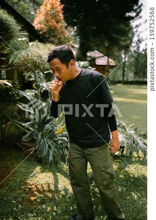 Southeast Asian Man Coughing Outdoors Southeast Asian Man Coughing Outdoors 139752568