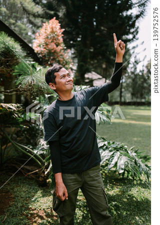 Southeast Asian Man Pointing Upward Outdoors Southeast Asian Man Pointing Upward Outdoors 139752576