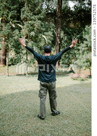 Asian Male Celebrating with Hands Up in Outdoor Area 139752578