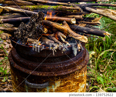 Sparks and smoke burning branches inside a rustic old barrel Sparks and smoke burning branches inside a rustic old barrel 139752622