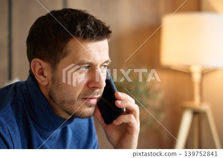 Man Talking On Smartphone At Home Man Talking On Smartphone At Home 139752841