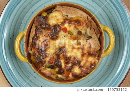 Baked vegetable and tortilla casserole with melted cheese 139753152