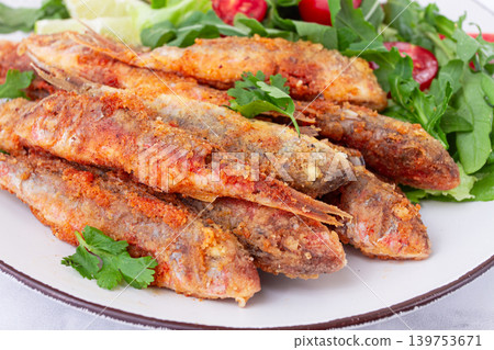 Fried crispy mullet fish, with fresh salad, on a plate with lime, no people, Fried crispy mullet fish, with fresh salad, on a plate with lime, no people, 139753671