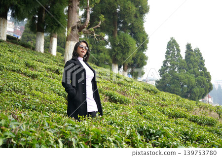 Elegant young woman posing in a lush green mountain tea garden at Darjeeling Elegant young woman posing in a lush green mountain tea garden at Darjeeling 139753780
