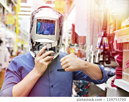 Men choose protective mask welder in store Men choose protective mask welder in store 139753790