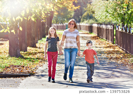 Mother with children walking in autumn park Mother with children walking in autumn park 139753826