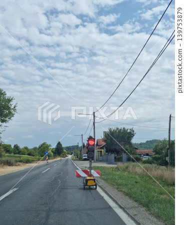 Portable traffic light on a rural road under construction Portable traffic light on a rural road under construction 139753879