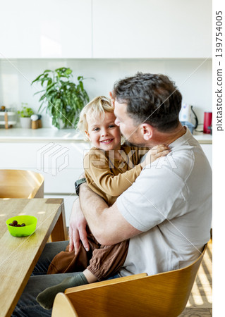 Young child and dad eating healthy snack during playful family moment. Young child and dad eating healthy snack during playful family moment. 139754005