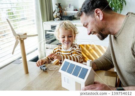 Father educating toddler about solar power and eco friendly living. Father educating toddler about solar power and eco friendly living. 139754012