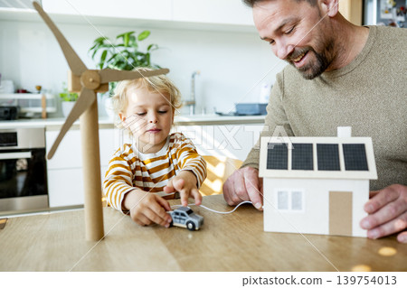 Father educating toddler about solar power and eco friendly living. Father educating toddler about solar power and eco friendly living. 139754013