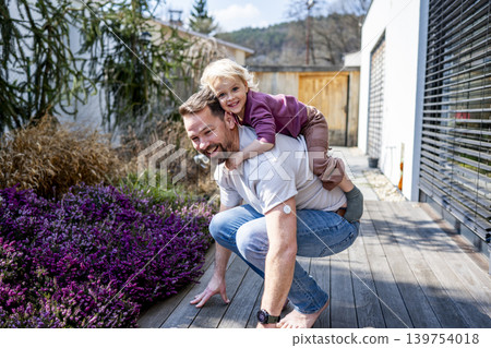 Diabetic dad enjoying playful moment with young son in backyard. 139754018