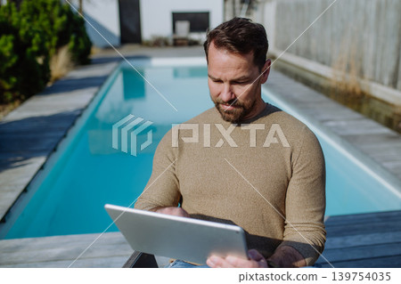 Man making online order or working from home on terrace. Man making online order or working from home on terrace. 139754035
