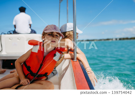 Kids enjoying boat ride during tropical vacation. Kids enjoying boat ride during tropical vacation. 139754042
