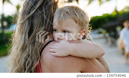 Mother embracing her little daughter in tropical beach resort. Mother embracing her little daughter in tropical beach resort. 139754046