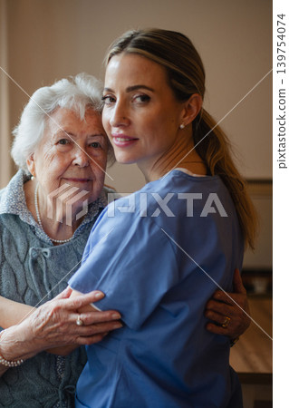Portrait of caring healthcare worker visiting a senior patient at home, hugging her. Portrait of caring healthcare worker visiting a senior patient at home, hugging her. 139754074