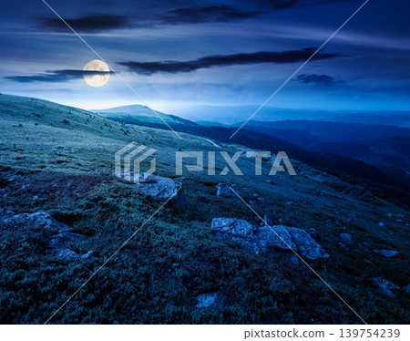 mountain summer landscape at night. full moon over meadow with giant stones among the grass on the hillside. mysterious view near the peak of mountain smooth in dappled light. great outdoors mountain summer landscape at night. full moon over meadow with giant stones among the grass on the hillside. mysterious view near the peak of mountain smooth in dappled light. great outdoors 139754239