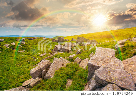 sunset over mountainous landscape during summertime. boulders and rock formations surrounded grassy hills. picture of an untouched highland. leadership corporate wallpaper under the rainbow sunset over mountainous landscape during summertime. boulders and rock formations surrounded grassy hills. picture of an untouched highland. leadership corporate wallpaper under the rainbow 139754249