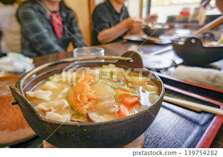 A dining table surrounding a Hoto hot pot, a specialty of Yamanashi Prefecture. A dining table surrounding a Hoto hot pot, a specialty of Yamanashi Prefecture. 139754282