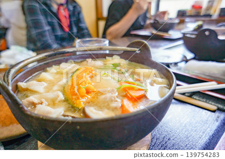 A dining table surrounding a Hoto hot pot, a specialty of Yamanashi Prefecture. A dining table surrounding a Hoto hot pot, a specialty of Yamanashi Prefecture. 139754283