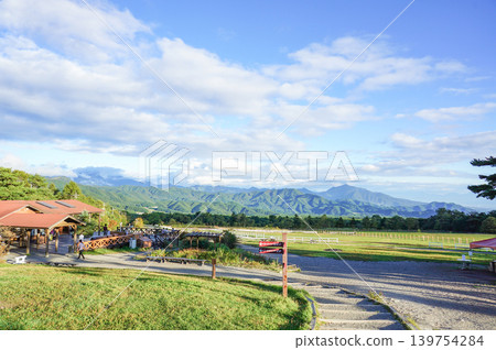 眼前是一片高原牧場景觀，藍天白雲，群山綿延。 139754284