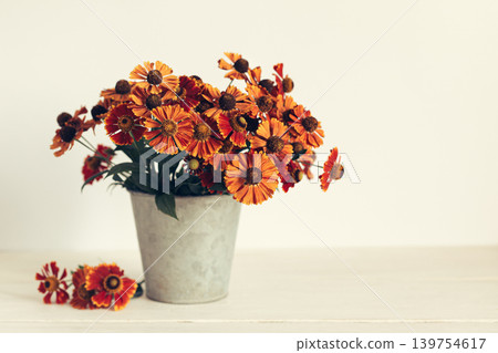 Autumn bouquet of bright flowers (Helenium autumnale) in a vintage pot. Concept for autumn background or postcard. Autumn bouquet of bright flowers (Helenium autumnale) in a vintage pot. Concept for autumn background or postcard. 139754617