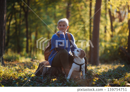 Senior woman with dog on walk outdoors in nature. Senior woman with dog on walk outdoors in nature. 139754751