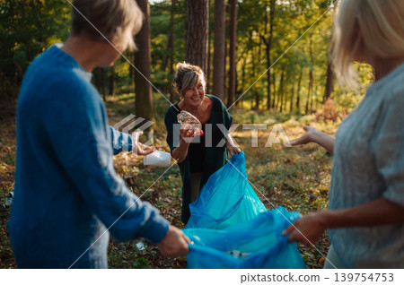 Senior women volunteering for nature protection and litter collection. Senior women volunteering for nature protection and litter collection. 139754753