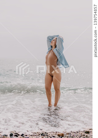 Woman beach ocean young female in bodysuit standing in sea water enjoying morning breeze and waves with copy space Woman beach ocean young female in bodysuit standing in sea water enjoying morning breeze and waves with copy space 139754857