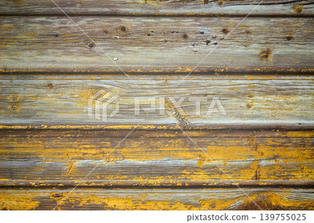 old wooden surface made of planks with remnants of peeling yellow paint close up 139755025