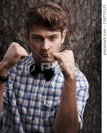 Fight, smoking and portrait of man in outdoors for challenge, strong and boxing. Cigarette, hipster and anger with face of male person and hands up in nature for combat, cool and trendy style Fight, smoking and portrait of man in outdoors for challenge, strong and boxing. Cigarette, hipster and anger with face of male person and hands up in nature for combat, cool and trendy style 139755125