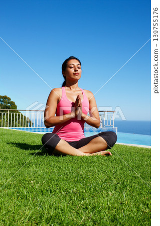 Meditation, yoga and woman on grass praying for holistic balance, mindfulness and breathing exercise. Meditating, hands in prayer and person by ocean for wellness, health and zen energy outdoors Meditation, yoga and woman on grass praying for holistic balance, mindfulness and breathing exercise. Meditating, hands in prayer and person by ocean for wellness, health and zen energy outdoors 139755176