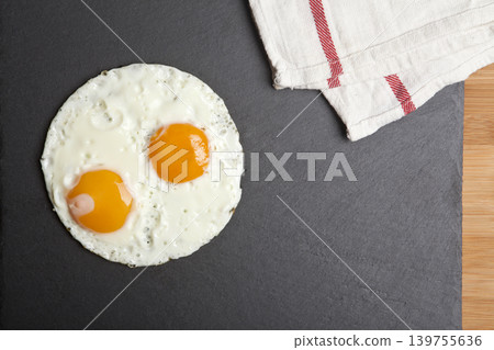 Serving fried eggs on a granite surface. Serving fried eggs on a granite surface. 139755636