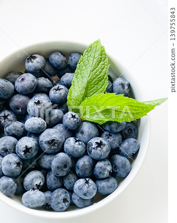 Fresh blueberries and mint on a white background. Fresh blueberries and mint on a white background. 139755843